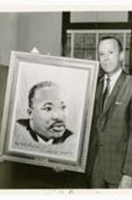 President Hugh Gloster with persons holding the Dr. Martin Luther King Jr. portrait dedicated to Morehouse College. Written on verso: September 1968 Haitian Ambassador to the US presents portrait of Dr. King, Jr. to Morehouse and confers Honorary Degrees of Pres. Gloster and Dr. Whalum.