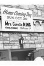 A sign announcing Home Coming Day and Coretta King hangs above the entrance of West Hunter Baptist Church with churchgoers outside.