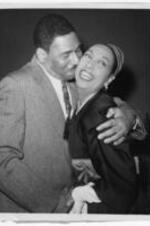 Frederick O'Neal kisses Josephine Baker on the cheek. Written on verso: Visits "Shakespeare in Harlem." New York: Frederick O'Neal, star of "Shakespeare in Harlem," kisses singer Josephine Baker backstage at the forty-first street theater after Jan. 11th performance. Miss Baker, who was born in America but is now a citizen of France, visited the cast backstage. 2-11-1960 JL
