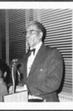A man speaks from the podium at an ITC event.