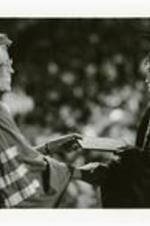 View of President Johnnetta B. Cole handing diploma to student at commencement.