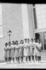 A group of female students stand outside of a building at Clark.