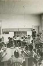 View of young people in a classroom reading.