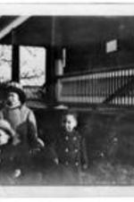 Children stand in front of a home.