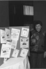 Evelyn G. Lowery is shown standing with an AIDS and Drug Abuse information display.