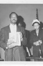 Robert Jones holds an award alongside Mrs. M. Burroughs at the 18th annual art exhibition.