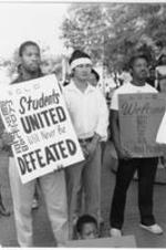 Southern Christian Leadership Conference (SCLC) staff member Frederick Moore (at right) stands with others holding signs expressing SCLC's support for Chinese students at a vigil event held at the grave site of Martin Luther King, Jr. More details about the vigil can be found on pages 96-99 of the July-August 1989 SCLC Magazine: http://hdl.handle.net/20.500.12322/auc.199:07095.