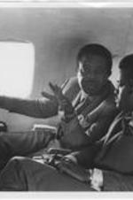 Ralph D. Abernathy is shown speaking with an unidentified man inside of an airplane.