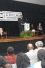 Dr. Clarence G. Newsome stands at the podium and delivers his lecture in front of an audience.