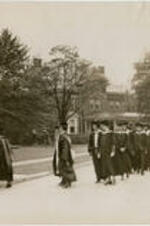 A line of faculty, students, and staff from the Atlanta University Center form a procession before the dedication of the Trevor Arnett Library. Written on verso: Atlanta University faculty leads the academic procession into Sisters Chapel on the occasion of the dedication of the new Atlanta University Library. Rain compelled the holding of the exercise indoors.