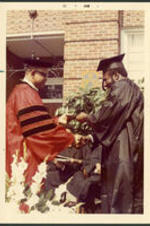 Dr. Vivian Wilson Henderson presenting a graduate with his degree at a commencement ceremony at Clark College in Atlanta, Georgia.