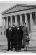 John H. Wheeler stands with others on the steps of a government building.