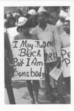 A group of people hold signs in the March Against Repression. Written on accompanying document: March Against Repression 5-23-70 began at Ebernezer - ended Morehouse College - marchers assymbling.