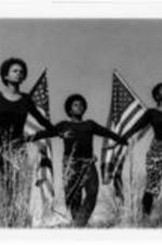 Three unidentified women stand in tall grass with their arms outstretched. Two unidentified men stand behind them holding up American flags. Written on verso: Echoes of a Dream, a dramatic bicentennial production of Boggs Academy, Keysville, Georgia, is  widely acclaimed program of dance, poetry and song speaking to the question of "should blacks celebrate the bicentennial?" Echoes will be presented on (date), at (place), at (time). It is sponsored by (name of sponsor). The public is invited.