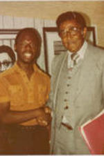 Southern Christian Leadership Conference (SCLC) President Joseph E. Lowery is shown shaking hands with Richard Burney at the 23rd Annual SCLC Convention. Written on verso: Richard Burney, SCLC Convention 1980, Cleveland, Ohio
