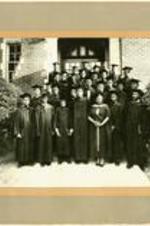 A class in graduation robes stand for a portrait on the steps of a Gammon campus building. Written on verso: Gammon's last class, 1959.