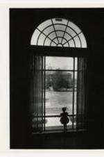 View of young girl looking out window of Laura Spelman Hall.