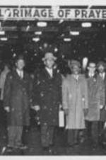 A group of Southern Christian Leadership Conference members stands below a marquee sign that says "Pilgrimage of Prayer". Written on verso: Virgil Wood, Melton Reed, Fred Shuttlesworth, Wyatt Walker, Curtis Harris