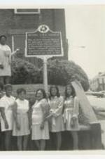 Outdoor group portrait of women in front of the historic site sign of Bethel AME Church.