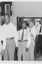 Unidentified men stand in line at a dining hall.