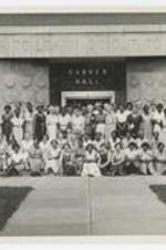 Outdoor group portrait of women in front of building "Enter to Learn - Go Out to Serve, Carver Hall".