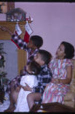 Anna Powell Henderson and the Henderson children sitting beside a Christmas tree.