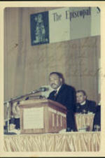 Martin Luther King Jr. speaking at an event. Written on recto: To Kim Dreisbeck with best wishes and warm regards, Martin Luther King, Jr.