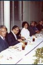 Dr. Robert Threatt dines at a banquet table with others inside the ITC dining hall.