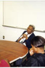 C. Eric Lincoln sits at a table and talks with a group of students.
