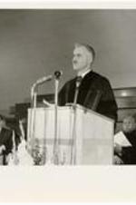 An unidentified man delivers a speech at a podium.