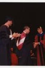 Colin Powell shakes hands with Thomas W. Cole, Jr., at the summer commencement.