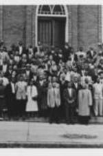 Martin Luther King, Jr. stands with Ralph D. Abernathy (standing to the right of King) and others on the steps of Dexter Avenue Baptist Church in Montgomery, Alabama.