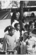 Children hold an African National Congress flag as part of an event paying tribute to Nelson Mandela. Written on verso: Children hold the ANC flag as they participate in the tribute to Mandela.