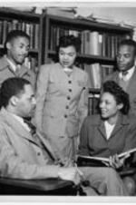 A group of students talk with Dr. Bacote. Written on verso: Bacote and group of students, February, 1947.