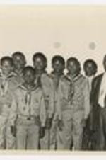 Group portrait of men and young boys in scout uniforms.