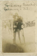 A couple stands together in their swimsuits. Written on recto: Rockaway Beach, Rockaway, N.Y.