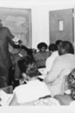 Reverend C.T. Vivian is shown speaking to a group of students during  the Southern Christian Leadership Conference's Black Student Summit held in Atlanta, Georgia. Written on verso: Rev. C.T. Vivian, SCLC Board Member and chairman of Center of Democratic Renewal addresses capacity crowd students during workshop encouraging the development of young black youth leadership in the 80's. Rev. Vivian was one of the featured workshop speakers during SCLC's Black Student Summit 86'.