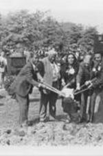 Jessie Hill, Martin Luther King, Sr., Coretta Scott King, Henry Ford, and Andrew Young shovel dirt as part of the groundbreaking ceremonies for Freedom Hall at The King Center. Written on verso: Jessie Hill, Daddy King, Mrs. King, Henry Ford, and Andy Young break ground for Freedom Hall.