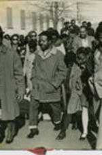 Ralph D. Abernathy is shown walking with others across a street in Memphis, Tennessee. Written on verso: Memphis after release from jail