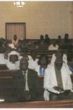 Members of the Shy Temple C.M.E. Church sit in rows of pews.