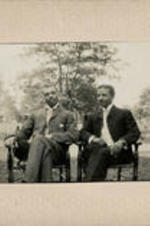 George A. Towns and James Weldon Johnson sit in a park and pose for a picture.