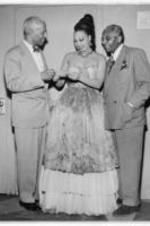 Josephine Baker purchases a ticket for the Negro Actors Guild 2nd Annual Benefit and Breakfast Dance. Written on verso: March 16, 1951. Josephine Baker purchasing the first ticket to the Negro Actors Guild 2nd Annual Benefit and Breakfast Dance (Savoy, April 6th) from Harold Jackman, Chairman of the Dance Committee, while looking on is Noble Sissle, President of the Guild.