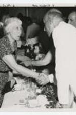 Banquet with Lillian Smith, Sam Nabrit, E. M. Martin shaking hands. Written on recto: Lillian Smith, Sam Nabrit, E.M. Martin.