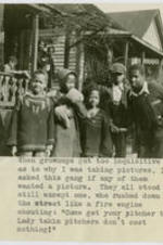 African American neighborhood children and family on porch and in the yard circa 1930. Written on recto: When grownups got too inquisitive as to why I was taking pictures, I asked this gang if any of them wanted a picture. They all stood still except one, who rushed down the street like a fire engine shouting: "Come get your pitcher took, Lady taking pitchers don't cost nothing!".