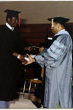 Unidentified man receives a diploma from President Grant Shockley.