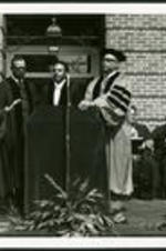 Dr.Vivian Wilson Henderson along with two unidentified men presenting an honorary degree to recipient Andrew Young, former Georgia congressman and mayor of Atlanta.