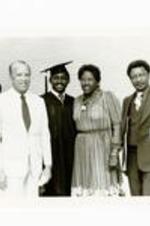 President Hugh Gloster with Morehouse graduate and parents. Written on verso: President Hugh M. Gloster with Kenneth Flowers '83 and his proud parents - May 22, 1983- Commencement.