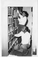 Students search library shelves.