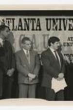 Dr. Thomas Cole and others stand on stage in front of a sign reading: Clark Atlanta University, a Child Survival Project event.