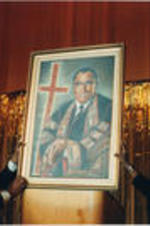 Two individuals hold a portrait of Joseph E. Lowery up for display.